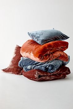 a stack of pillows sitting on top of each other in front of a white wall