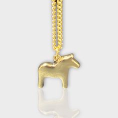 Dala Horse Necklace by Anna Viktoria Designed by Anna Viktoria Horse 2x2cm, Chain 42cm Available in Gold or Silver with matching earrings (sold separately) Made in Sweden All our gold and silver jewelry is in gold-plated iron. Nickel Free. Avoid contact with water. The Dala horse is a traditional Swedish symbol of good luck and prosperity. This beautiful necklace features a delicate plane Dala horse pendant on a silver or gold chain. It is the perfect way to add a touch of Scandinavian charm to Gold Horse Design Pendant Necklace, Gold Pendant Necklace With Horse Design, Metal Horse Design Jewelry Gift, Gold Plated Pendant Necklaces Cadmium-free, Gold Plated Pendant Necklace, Cadmium-free, Elegant Gold Jewelry With Horse Design, Horse Design Pendant Jewelry Gift, Nickel-free Yellow Gold Metal Necklace, Swedish Symbols