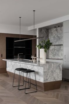 a kitchen with marble counter tops and stools