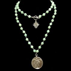 The St. Michael Victory Medallion in Aventurine is 35" long and features the St. Michael Victory Angel Medallion. The 8mm Aventurine gemstones are hand-linked with prayerful intention for the wearer. It is absolutely beautiful all by itself or layered with our other designs. This necklace is long enough to be worn doubled quite comfortably (as shown in first picture). A silver Fleur de Lis accents the clasp to be worn in the front when you wear it doubled or as a lovely enhancement when worn on Adventurine Necklace, Trinity Necklace, Heart Cross Necklace, Gold Bracelets Stacked, Wearing Jewelry, Healing Gemstones, Pearl Necklace Designs, Gold Diamond Necklace, Cluster Necklace