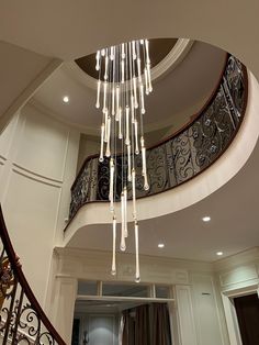 a chandelier hanging from the side of a spiral staircase