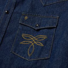 an embroidered dragonfly on the back of a denim shirt