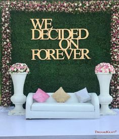 we decided on forever sign in front of a couch with pink and white flowers around it