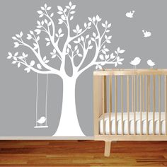 a baby's room with an owl and tree wall decal