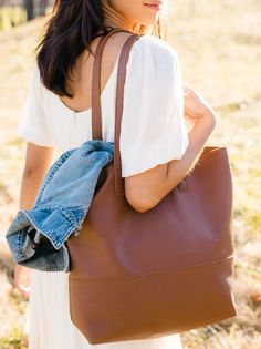 Our lifetime favorite and consistent bestseller, the Mamuye Classic Tote is the perfect everyday tote. Crafted with the highest quality, this bag is made to stand the test of time. Handcrafted in Ethiopia Unlined interior 100% leather Tote measures 14" H x 16" W x 6" D Comfortable, durable straps (straps have a 10.5" drop) Interior pocket Subtle variations add to the uniqueness of each product Product naturally produces a distressed look with wear This product is named after one of the heroic wo Classic Hobo Bag With Smooth Grain, Classic Smooth Grain Hobo Tote Bag, Classic Hobo Bag Tote With Smooth Grain, Versatile Everyday Hobo Bag With Leather Lining, Versatile Bucket Bag With Smooth Grain For Everyday Use, Classic Soft Leather Hobo Bag For Everyday, Daily Leather-lined Satchel Hobo Bag, Classic Everyday Hobo Bag For Fall, Leather Lined Satchel Hobo Bag