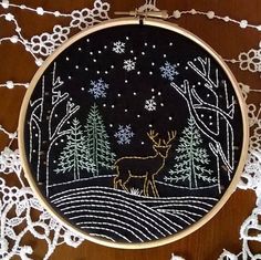 an embroidered deer in the woods at night