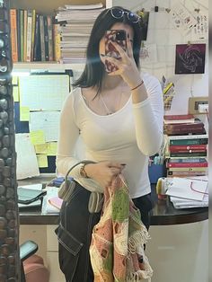 a woman taking a selfie in front of a mirror with her hand on her purse