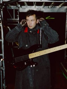 a man holding a guitar while standing next to a microphone