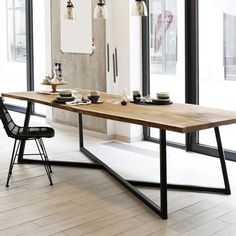 a dining table with two chairs and plates on it in front of large glass windows