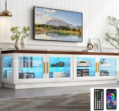 an entertainment center with remote controls and pictures on the wall