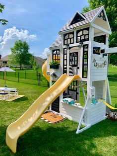 a play house with a slide in the grass