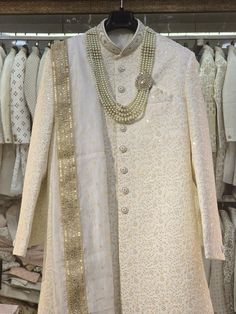 Make a grand statement on your special day with a luxurious Sherwani crafted from premium fabrics (like silk, brocade, or georgette) for ultimate comfort and sophistication. Our collection boasts a variety of designs to suit every taste: Classic elegance: Opt for a timeless Sherwani with intricate embroidery on the collar or cuffs. Modern flair: Go for a Sherwani with a unique neckline or a trendy color palette. Regal opulence: Choose a Sherwani with rich embellishments like zardozi work for a t Gold Traditional Wear With Naqshi For Reception, Formal White Raw Silk Traditional Wear, White Naqshi Dupatta For Wedding, Traditional White Dupatta For Formal Occasions, Gold Sherwani With Dupatta For Reception, Gold Sherwani With Naqshi For Wedding, Gold Long Traditional Wear For Reception, Gold Wedding Sherwani With Naqshi Detailing, Gold Naqshi Sherwani For Wedding