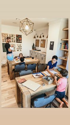 a group of children sitting at desks in a room with pictures on the wall