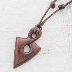 In the shape of a spearhead the pendant of this necklace is hand-carved from a piece of natural estoraque wood that displays a beautiful dark brown hue. Costa Rican artisan Milagro Cascante creates this striking necklace which circles the neck with an adjustable length of cotton cord. Brown Carved Amulet Necklaces, Brown Carved Pendant Necklace, Adjustable Carved Brown Necklace, Bohemian Brown Arrowhead Necklace, Brown Arrowhead Necklace For Gift, Wood Sculpture Art, Fantasy Craft, Wood Jewelery, Vehicle Reference