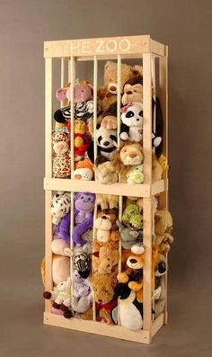 a wooden rack filled with stuffed animals on top of a floor next to a wall