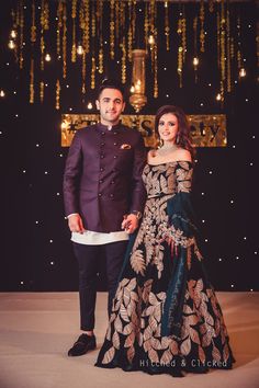 a man and woman standing next to each other in front of a stage with lights