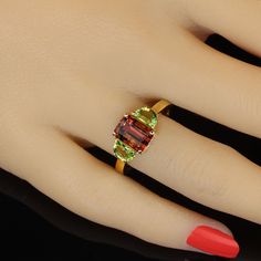 Rare and unusual orange Tourmaline accented with twin half moon Peridot set in gold rhodium over Sterling Silver ring. This gorgeous, clean, sparkling Tourmaline is that fantastic orange shade that is so covented. This is a 2.70ct beauty straight from one of our favorite vendors in the mountains outside of Rio de Janeiro. The Peridot are just the right shade of green to accent the orange of the Tourmaline. No changes by seller. This is a sizable 8. Sizable by your local jeweler. MR2328 Orange Tone, Rare Beauty, Peridot Ring, Green Peridot, Tourmaline Ring, I Love Jewelry, Vibrant Green, Three Stone Rings, Precious Gemstones