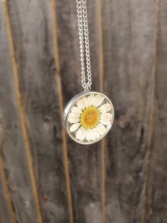 *Beautiful handcrafted real daisy necklace set in resin. *Add some spring sunshine to an outfit *Pendant is resin with a real daisy set inside April birth flower  *Pendant is 28mm x 28mm *Chain is 18 inches and gold plated for gold pendant and silver plated for silver pendant Please let me know if you require a different length chain. *Jewellery care* Please do not shower or sleep with this necklace on and avoid harsh chemicals. Please contact me with any enquiries and thank you for looking at my page Daisy Resin Necklace, White Flower-shaped Jewelry With Sunflower Design, White Flower Jewelry With Sunflower Design, White Sunflower Design Flower Jewelry, Everyday Flower Necklace With Flower Charm, Handmade White Flower Shaped Necklace, Yellow Flower Necklaces With Birth Flower Detail, White Flower Necklace With Nature-inspired Style, Yellow Flower Necklace With Birth Flower Detail