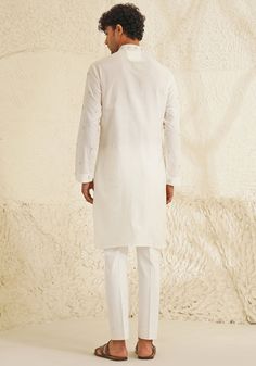 Presenting an exquisite Porcelain White Silk Kurta Set, featuring a sophisticated Chinese collar, elegant metallic silver buttons, and intricate hand-embroidered detailing on the neckline and sleeves. Paired with trendy white pants, this ensemble is perfect for engagements, Roka ceremonies, or puja events, combining timeless elegance with contemporary style. Composition : Dupion Silk Care: Dry Clean Only and Vacuum Storage This product can be customized for sleeves, length and colour Delivery : 4-6 weeks as the product is hand crafted. Check Size Guide or choose MySize for free customisation (All Sizes above XL can be made at 15% additional cost) For more information and sizes please contact fabiliciousfashion@gmail.com or visit our Copenhagen studio. About the Designer : Shreyansh, a dist Designer Wear Fitted White Nehru Jacket, Designer White Fitted Nehru Jacket, Designer Fitted White Nehru Jacket, White Fitted Nehru Jacket For Designer Wear, Cotton Bandhgala For Formal Festive Occasions, Elegant Cotton Nehru Jacket With Chikankari Embroidery, Formal Cotton Bandhgala For Festive Occasions, Designer Cotton White Nehru Jacket, Designer White Cotton Nehru Jacket