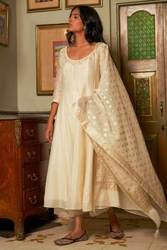 Ivory anarkali featuring sequin and pearl embroidered floral motifs on neckline. Comes with matching pant and chanderi banarasi dupatta.
Components: 3
Pattern: Embroidered
Type Of Work: Aari,Sequin,Crystal
Neckline: Round
Sleeve Type: Three quarter
Fabric: Anarkali: Chanderi,Pant: Cotton, Dupatta: Chanderi Banarasi
Color: Ivory
Other Details: 
Attached lining
Panelled anarkali
Sheer pant border
Note: Banarasi fabric will have slight variation as it is subject to availability
Occasion: Mehendi an Ivory Anarkali, Banarsi Dupatta, Kurta Set Design, Sheer Pants, Ready To Wear Saree, Indian Wedding Wear, Indian Fashion Designers, Pernia Pop Up Shop, Embroidered Clothes