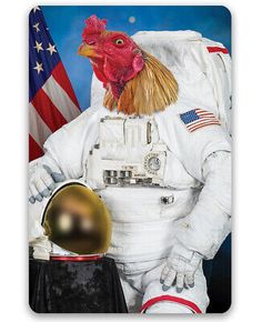 a rooster dressed in an astronaut suit and holding a golden helmet with the american flag behind it