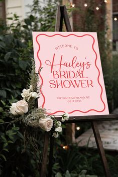 a sign that says, welcome to the bridal shower with flowers and greenery