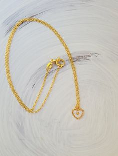 This sweet mustard seed necklace is a wonderful little piece, perfect for any occasion. The tiny mustard seed is suspended in glassy resin in a small textured gold heart. A wonderful reminder to keep the faith. #mustardseed Everyday Delicate Gold Heart Necklace, Yellow Necklace With Heart Charm For Gift, Everyday Gold Charm Necklaces With Heart Beads, Tiny Gold Pendant Necklace, Delicate Gold Heart Charm Necklace, Tiny Gold Plated Charm Necklaces, Tiny Gold-plated Charm Necklaces, Tiny Gold Plated Gold Necklaces, Yellow Heart Pendant Necklace For Valentine's Day