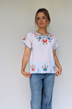 The vibrant floral embroidery makes this cool summer top! With blues, reds, oranges, pinks and greens and the sleeves are trimmed with the bright blue with a scalloped edging which repeats at the bottom hem with little faux slits.  Size: UK 10-12, Europe 38-40, US 6-8 Measurements: Bust 39 Inches, Bottom width 39 Inches Care: Cool machine wash Era: Est 70s Condition: Excellent vintage Brand: Linda of Mexico Material: Polyester Summer 70s, 70s Tops, Boho Blouse, Vintage Mexican, Vintage Branding, Blouse White, Boho Blouses, White Summer, Bottom Clothes