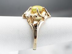 This vintage gold flower ring holds a rare gem mined in Sri Lanka and India for the most part, the stone is a cat's eye chrysoberyl. The soft, mossy yellow-green is reminiscent of a cat's eye, and the reflection of light inside this phenomenal stone gives the impression that the eye is watching, looking around where the hand is moved. Metal: 10K Yellow Gold Gem: Cat's Eye Chrysoberyl 1.56 Carats Gem Measurements: 7.1 mm, Round Ring Size: 7 Marks: "10K" Stamped on the inside band Yellow Gold Sapphire Ring, Gold Flower Ring, Right Hand Ring, Gem Mining, Gold Statement Ring, Floral Ring, Cameo Ring, Right Hand Rings, Hand Ring