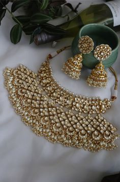 The majestically handcrafted kundan necklace set is an ode to the Indian tradition and intricate work handcrafted by the artisans. The bridal necklace embedded with high grade kundan and shell pearls hanging is a masterpiece inspired by Sabyasachi jewelry. The kundan jhumka earrings paired with the necklace are perfect for all the beautiful brides-to-be!  Pair this replica of an ancestral jewelry necklace set with your traditional ensembles and create a look to remember.  Necklace Closure - Adju Luxury Bridal Necklace With Intricate Design For Diwali, Luxury Bridal Necklace With Latkans For Reception, Luxury Bridal Chandbali Necklace With Stone Work, Luxury Ceremonial Bridal Necklace With Zari Work, Kundan Wedding Jewellery, Luxury Intricate Bridal Necklace For Puja, Traditional Festive Jewelry With Gota Work, Traditional Jewelry Sets With Gota Work For Celebration, Traditional Temple Necklace With Gota Work For Celebration