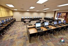 an empty classroom with laptops and desks in the middle is shown for everyone to see