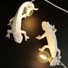 two white gecko lamps sitting on top of a table