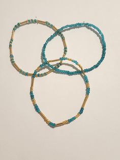 The bracelets are about 7 inches long and made with glass seed beads and stretchy string. Turquoise Beaded Bracelets With Gold Beads As Gift, Turquoise Heishi Beads Bracelet With Tiny Beads, Adjustable Turquoise Stretch Bracelet With Tiny Beads, Turquoise Beaded Bracelets With Gold Beads, Turquoise Beaded Bracelets With Gold Accents, Turquoise Stretch Bracelet With Tiny Beads For Beach, Turquoise Heishi Beads Bracelets, Blue Heishi Beads Bracelet With Gold Accents, Blue Heishi Beads Bracelet With Gold Beads