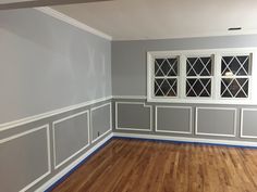 an empty room with wood floors and gray walls