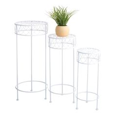 three white metal plant stands with a potted plant on one side and two smaller ones on the other