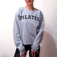 Unleash your inner Pilates enthusiast with our 'Reformer Spring' sweatshirt, a trendy tribute to your favorite workout! Adorned with bold 'PILATES' lettering and featuring iconic reformer springs graphics down the sleeves, this cozy grey sweatshirt is sure to spring you into style while declaring your love for the art of controlled movements. Ideal for any situation, a unisex heavy blend crewneck sweatshirt is pure comfort. The classic fit along with the crew neckline deliver a comfy wearing exp Athletic Heather Relaxed Fit Sweats For Athleisure, Athletic Heather Relaxed Fit Sweats Athleisure, Relaxed Fit Athletic Heather Sweats For Sports, Heather Grey Athleisure Sweats For Sports, Athletic Heather Sweats With Ribbed Cuffs For Sports, Stretch Crew Neck Sweatshirt For Workout, Sweat Resistant Crew Neck Sweatshirt For Athleisure, Athleisure Crew Neck Sweater For Sports, Crew Neck Athleisure Sweater For Sports