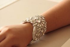 a close up of a person's arm wearing a bracelet with jewels on it