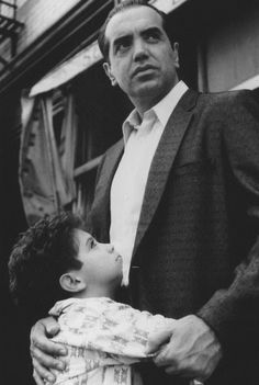 a man in a suit holding a small child