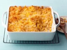 a casserole dish on a cooling rack next to a plate with a spoon