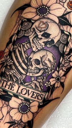 a tattoo on the leg of a person with flowers and a skeleton holding a heart