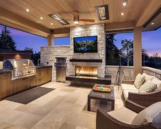 an outdoor living room with fireplace and grill