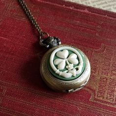 Medium 30mm pocket watch necklace with a high quality quartz movement inside.  On the front is a resin cameo of a claddagh and clover.On 28 inches of antiqued brass chain.I can make this chain any length for no extra charge. Just leave me a note at checkout!You can adjust the time by pulling up the knob and turning.Pressing the knob opens the watch.Each watch comes with a spare battery and printed care instructions. Vintage Good Luck Locket Jewelry, Timeless Jewelry With Antique Finish As Gift, Vintage Brass Jewelry For Good Luck, Oc Creator, Dnd Items, Pocket Watch Necklace, Christmas Gifts For Girlfriend, Vintage Style Jewellery, Cameo Necklace