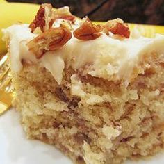 a close up of a piece of cake on a plate with a banana in the background