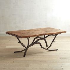 a wooden table sitting on top of a hard wood floor next to a white wall