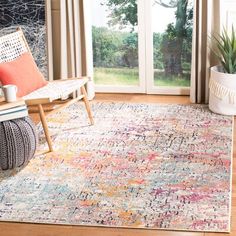 a living room area with a rug, chair and large glass door leading to an outside patio