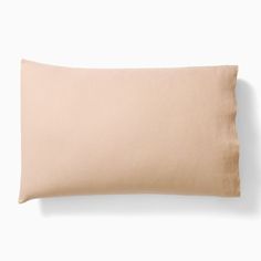 a beige pillow sitting on top of a white wall