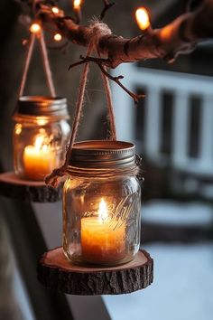 two mason jars with candles hanging from them