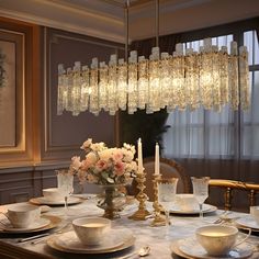 a dining room table with plates, cups and saucers on top of it in front of a chandelier