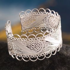 Superbly crafted in the style of Catacaos this cuff bracelet is inspired by colonial treasures. Alfredo Inga creates frothy ocean waves that surround the wrist like lace. He works in Andean silver creating the filigree images with strands of fine silver. .999 and .925 silver Luxury Filigree Cuff Bracelet For Formal Occasions, Ornate Adjustable Cuff Bracelet With Intricate Design, Adjustable Ornate Cuff Bracelet With Intricate Design, Adjustable Filigree Bohemian Cuff Bracelet, Bohemian Adjustable Cuff Bracelet With Intricate Design, Artisan Cuff Bracelet With Intricate Adjustable Design, Elegant Cuff Bracelet With Intricate Design, Artisan Adjustable Cuff Bracelet With Intricate Design, Intricate Sterling Silver Cuff Bracelet