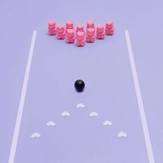 several pieces of pink gummy on a purple surface with white lines and black balls